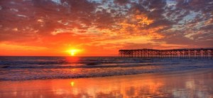 sunrise on the horizon with reflective light on the shore